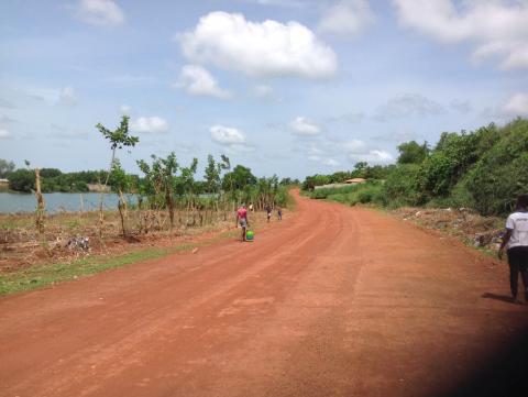 Residents walk along a route beside a mined out pit in Rutile