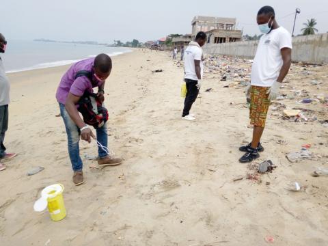 SLYDCL field officers collect needles and syringes along Levuma Beach in the west end of Freetown